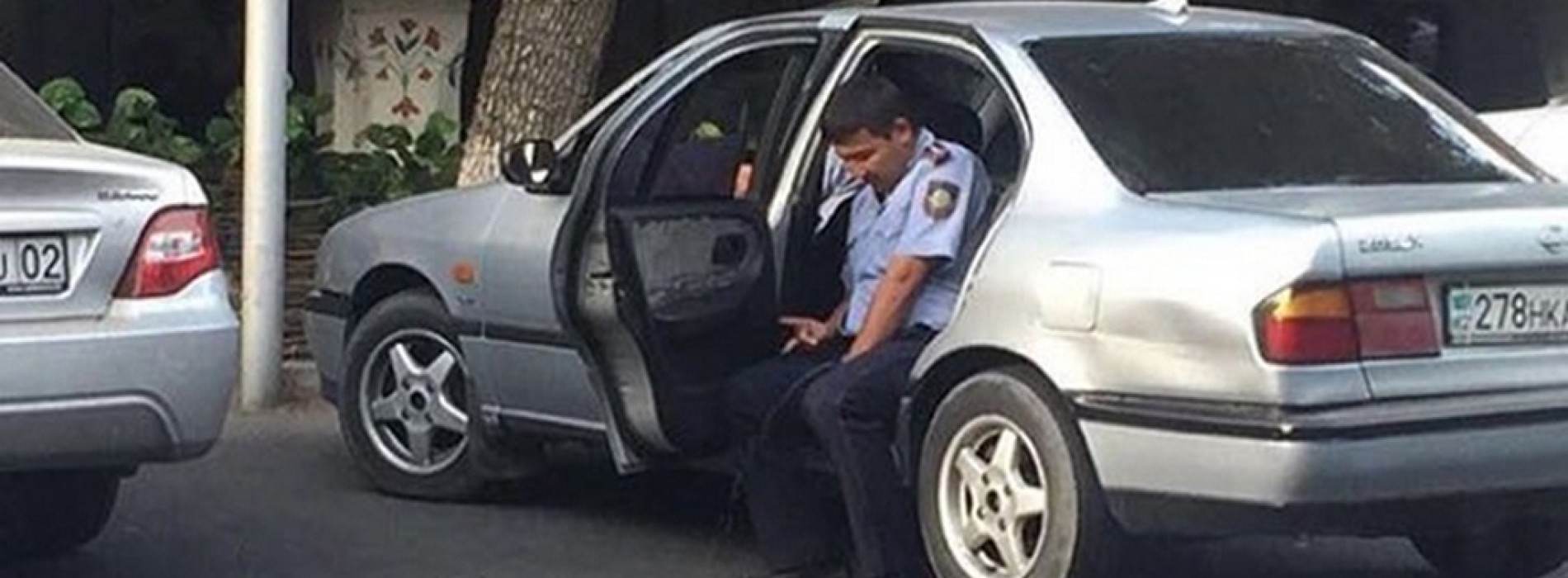 Стал известен владелец автомобиля, который попал на фото с писающим полицейским